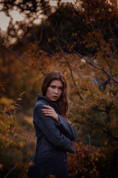 Beautiful asian girl in gray coat enjoy autumn forest The idea and concept of walks in the fresh air and freedom