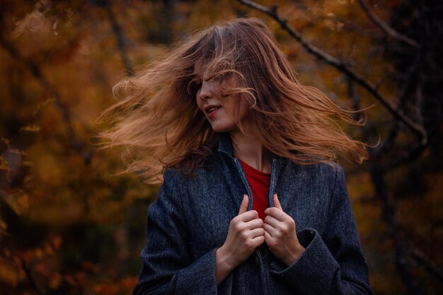 Beautiful asian girl in gray coat enjoy autumn forest The idea and concept of walks in the fresh air and freedom