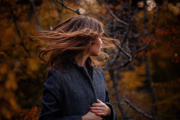 Beautiful asian girl in gray coat enjoy autumn forest The idea and concept of walks in the fresh air and freedom