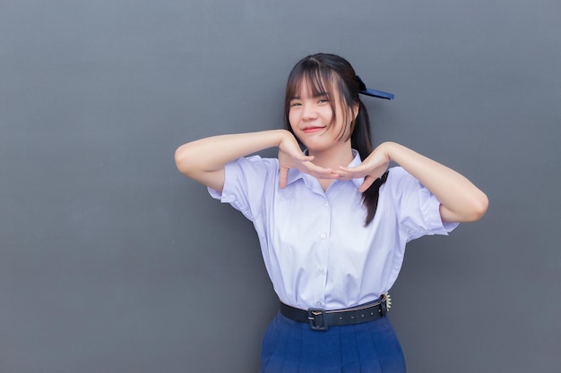 Beautiful Asian high school student girl in the school uniform with smiles confidently.