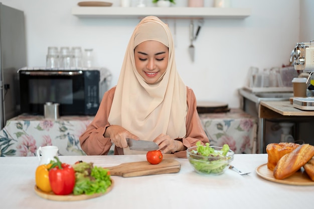 A beautiful Asian Muslim woman is preparing ingredients for her salad mix in a kitchen