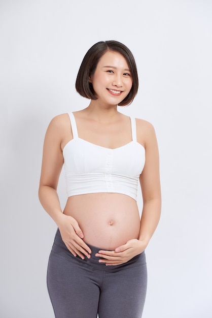 Beautiful asian pregnant woman expecting baby and touching her belly