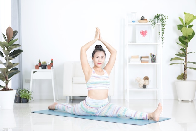 Beautiful asian sports woman performs the exercises at home .Yoga