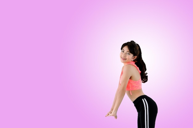 Beautiful asian sporty young girl in sport suit pose for take a photo on white and pink backgroundsport style concept