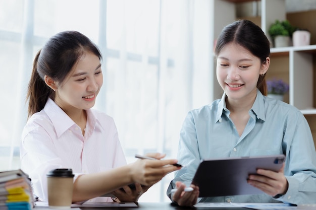 Beautiful Asian woman chatting with colleague in company office businesswoman operating company administration staff working as a team in department for planning meeting Working women concept