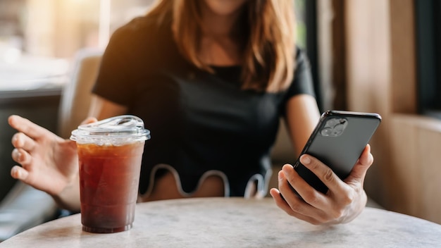 Beautiful asian woman holding and using digital tablet while drinking coffee at home office and cafexA