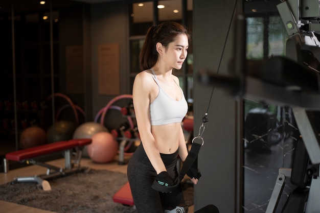 Beautiful asian woman is doing exercise in the gym