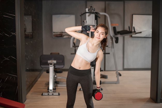 Beautiful asian woman is doing exercise in the gym