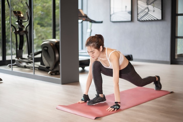 Beautiful asian woman is doing exercise in the gym