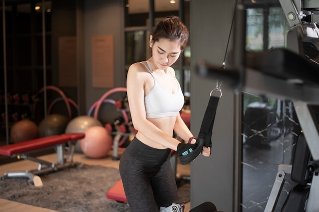 Beautiful asian woman is doing exercise in the gym