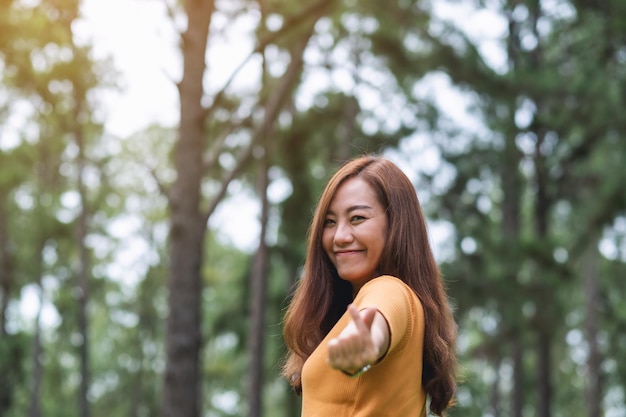 A beautiful asian woman making mini heart hand sign in the park