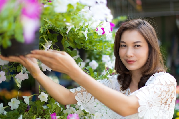 Beautiful Asian woman selecting flower in floral shop, lifestyle of modern housewife.