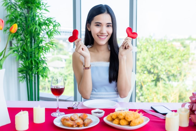 Beautiful asian woman showing two hearts