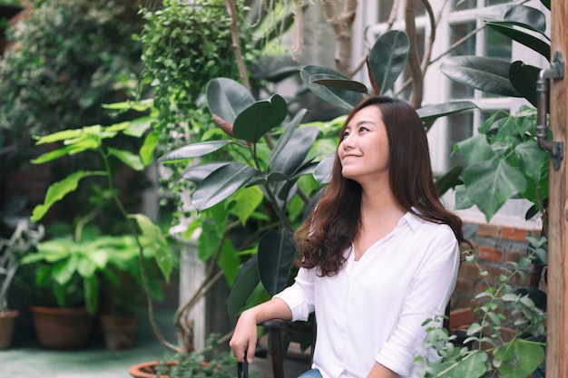 A beautiful asian woman sitting among the trees and nature