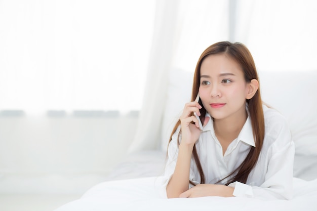 Beautiful asian woman smiling lying and relax on the bed in the morning