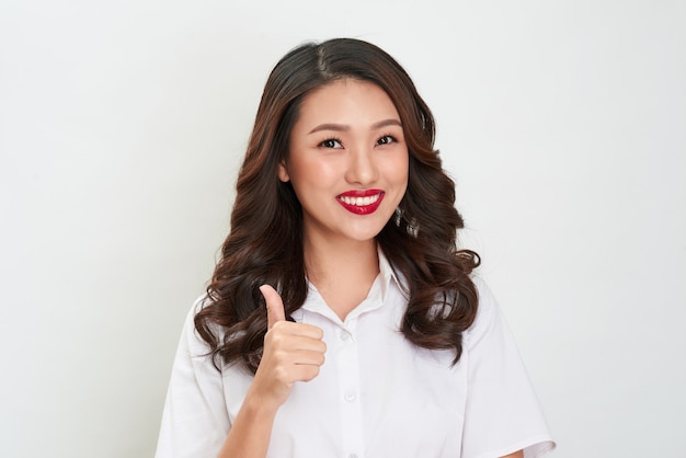 Beautiful asian woman smiling and showing good sign. Presenting your product.