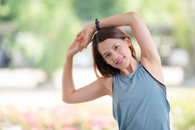 A beautiful Asian woman in sports outfits doing stretching before workouts exercise at home