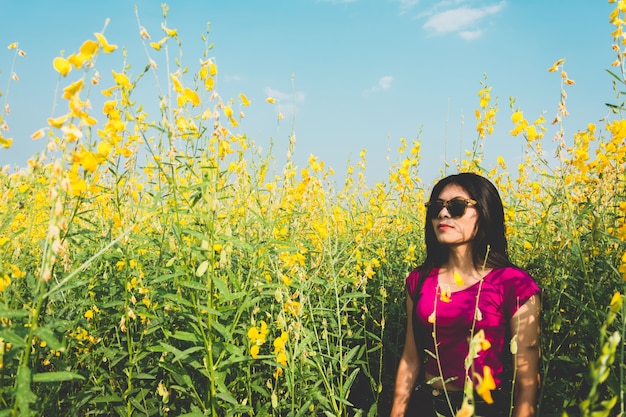 Beautiful Asian Woman standing in sunhemp field at countryside