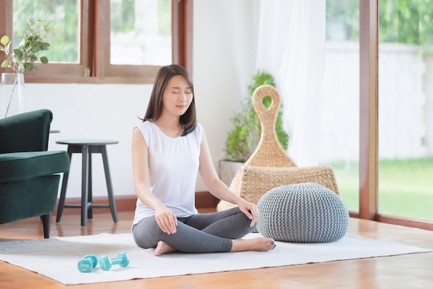 Beautiful asian woman staying fit by exercising at home for healthy trend lifestyle