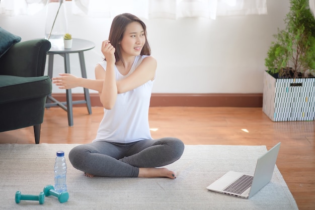 Beautiful asian woman staying fit by exercising at home for healthy trend lifestyle