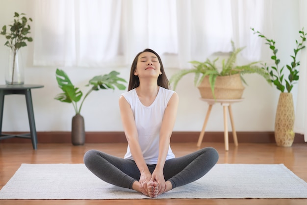 Beautiful asian woman staying fit by exercising at home for healthy trend lifestyle