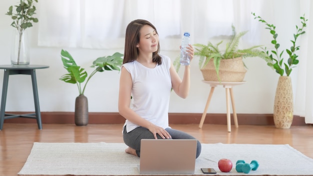 Beautiful asian woman staying fit by exercising at home for healthy trend lifestyle