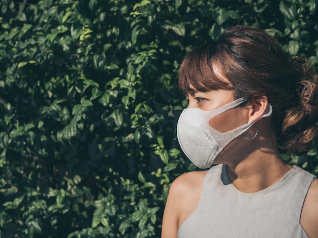 Beautiful asian woman wearing white protective N95 mask