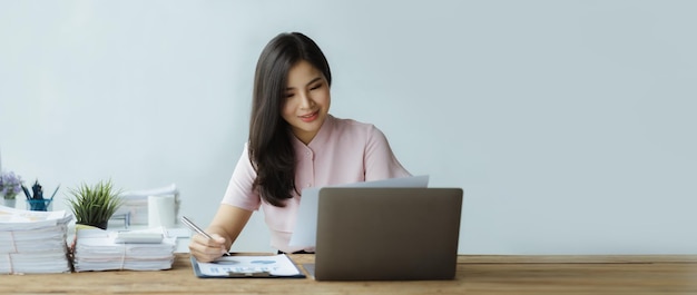 Beautiful Asian woman working with computers in the office of a startup company she is a company finance employee working in the finance department Concept of women working in a company