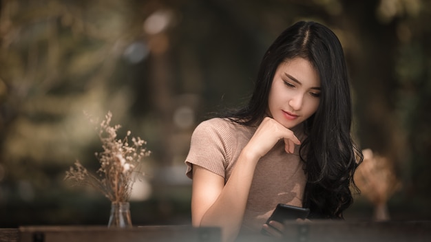 Beautiful asian women girl sitting are checking massage on mobile phone in the park 