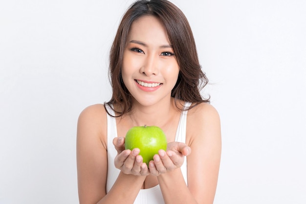 Beautiful asian young woman healthy food wearing white underwear holding green apple with healthy food isolated on a white background