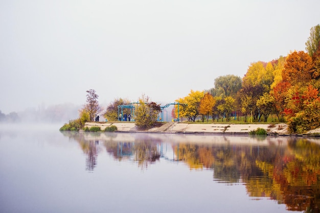 Beautiful autumn landscape with mist over the lake in forest