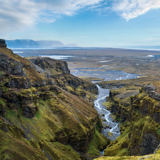 Beautiful autumn view from Mulagljufur Canyon to Fjallsarlon glacier with Breidarlon ice lagoon Iceland and Atlantic Ocean in far It is south end of Vatnajokull icecap and Oraefajokull volcano