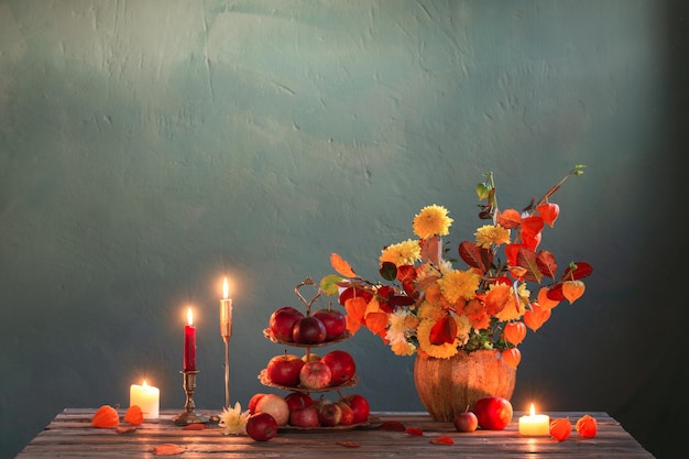 Beautiful autumnal bouquet on wooden table on dark wall