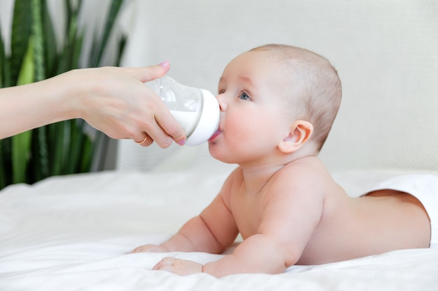 Beautiful baby eating milk from bottle