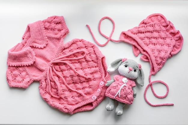 Beautiful baby knitted clothes and a toy for a newborn baby