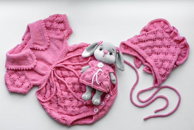 Beautiful baby knitted clothes and a toy for a newborn baby