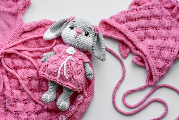 Beautiful baby knitted clothes and a toy for a newborn baby