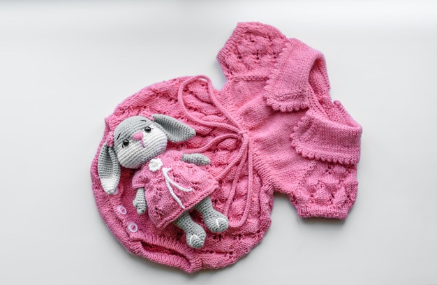 Beautiful baby knitted clothes and a toy for a newborn baby