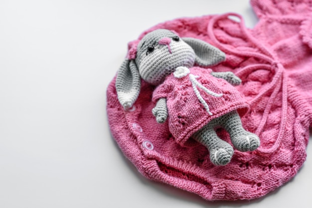 Beautiful baby knitted clothes and a toy for a newborn baby