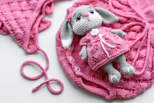 Beautiful baby knitted clothes and a toy for a newborn baby