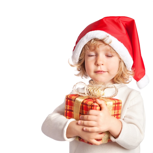 Beautiful baby making a wish with Christmas gift box. Isolated on white background