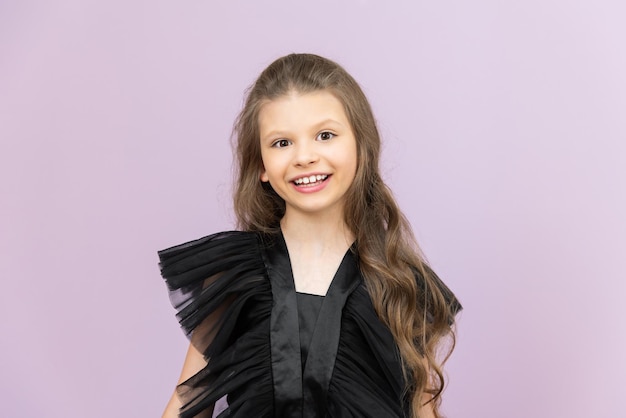 Beautiful baby on pink isolated background A beautiful little girl in a black fluffy dress