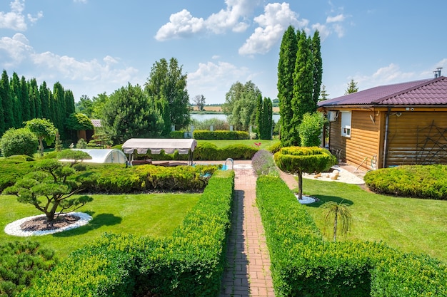 Beautiful backyard garden with nicely trimmed trees bushes and stones