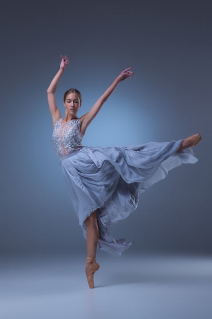 The beautiful ballerina dancing in blue long dress