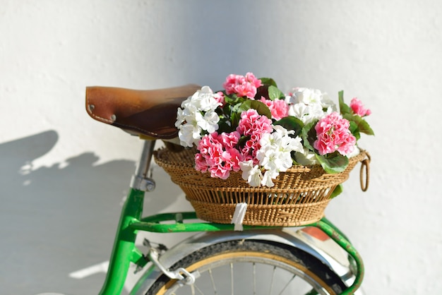 Beautiful basket with geraniums on a vintage bicycle