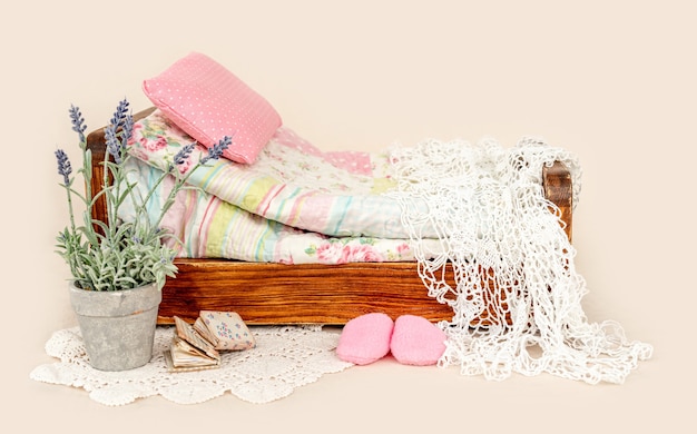 Beautiful bed furniture for newborn studio photoshoot with purple flowers decoration, pink pillow and blankets. Tiny designed place for infant photo isolated on background