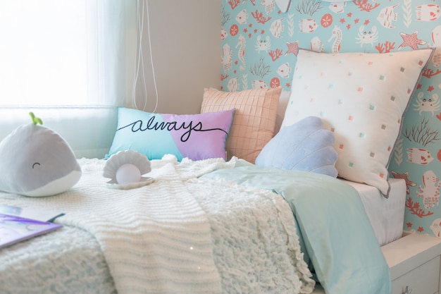 A beautiful bedroom kids with a sweet pillows and doll.