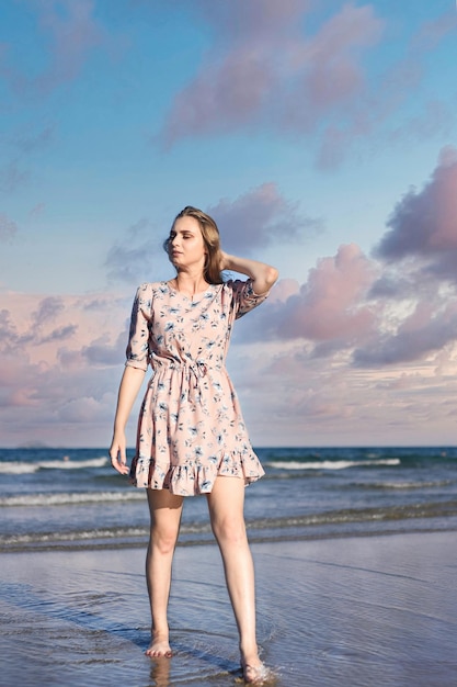 Beautiful Belarus woman walking on the beach against dramatic and romantic sky