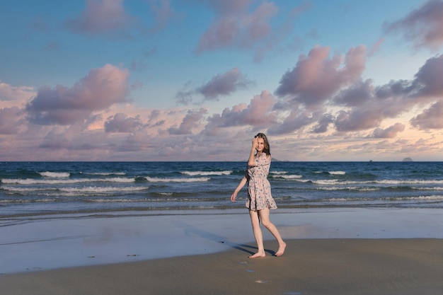 Beautiful Belarus woman walking on the beach against dramatic and romantic sky