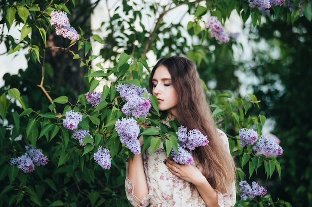 Beautiful big-eyed girl near the lilac tree. 